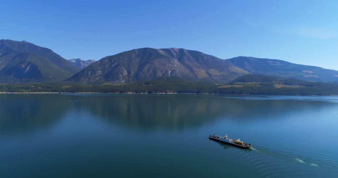 A serene lake with a lone boat surrounded by mountains - Free Images, Stock Photos and Pictures on Pikwizard.com