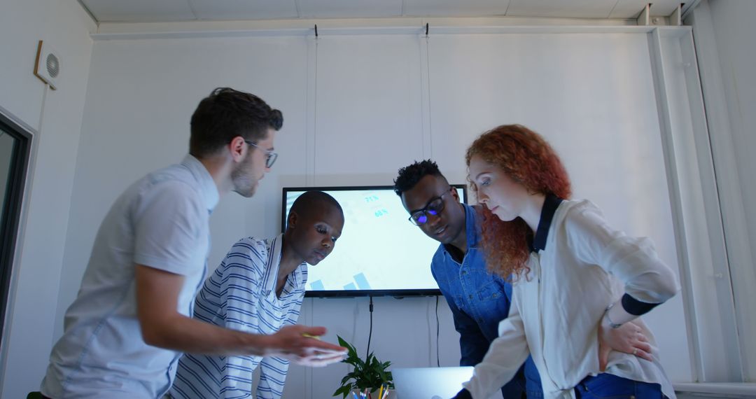 Diverse Team Collaborating Over Laptop in Casual Workspace