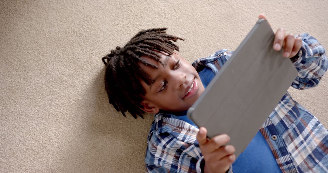 Cheerful Boy Enjoying Tablet Technology on Carpet