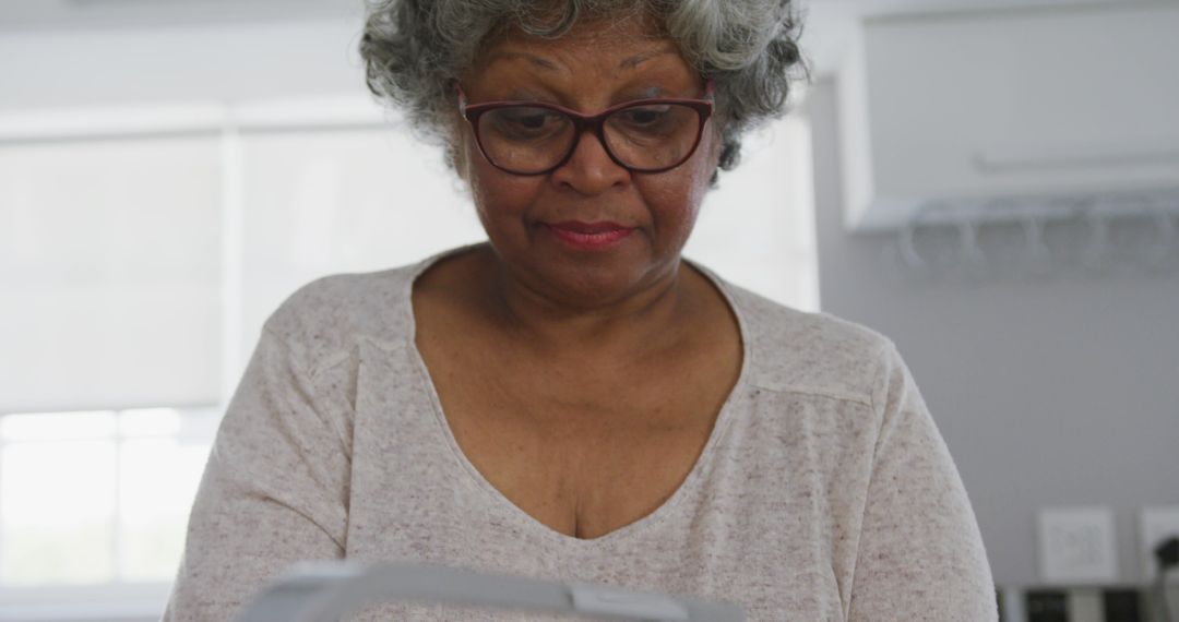 Senior Woman with Gray Hair Wearing Glasses Using Kitchen Appliance - Free Images, Stock Photos and Pictures on Pikwizard.com