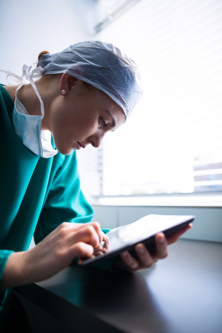 Focused Female Surgeon Using Digital Tablet in Hospital - Free Images, Stock Photos and Pictures on Pikwizard.com