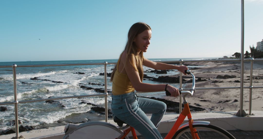 Young Woman Riding Bike by Beach on Sunny Day - Free Images, Stock Photos and Pictures on Pikwizard.com