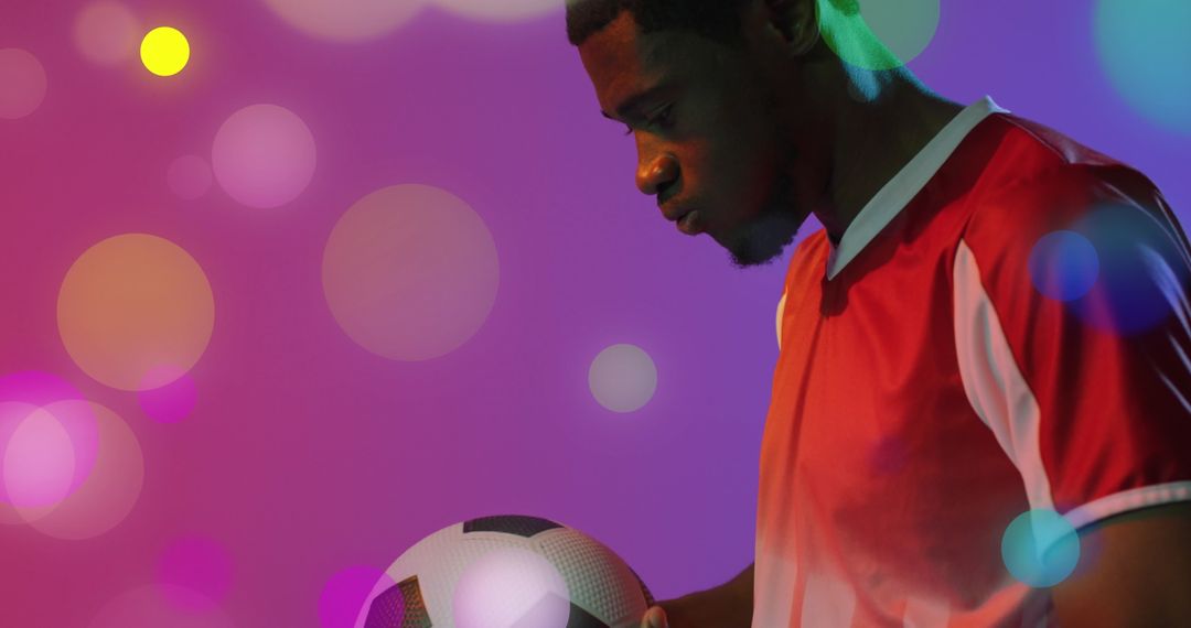 Soccer Player Posing with Ball Against Colorful Backdrop