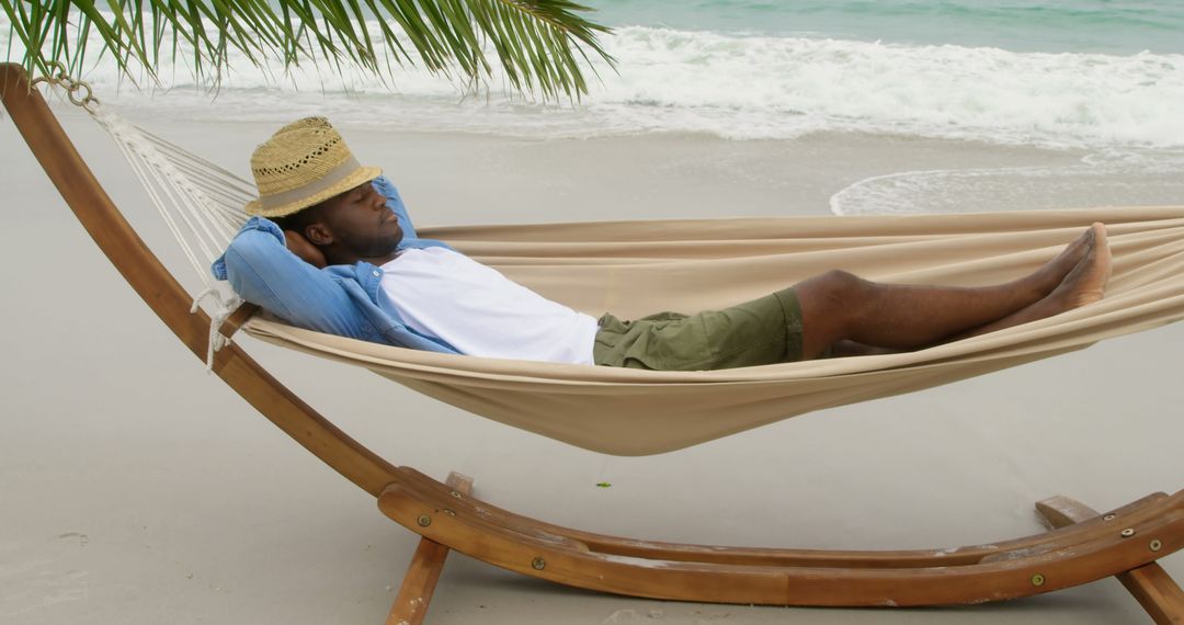 African American Man Relaxing in Hammock on Tranquil Beach