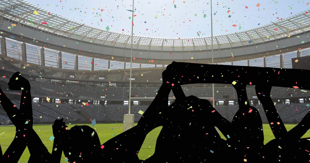 Silhouetted Fans Cheering in Stadium with Colorful Confetti Falling