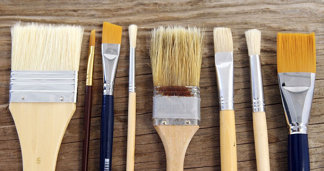 Assorted Paintbrushes Lined Up on Wooden Surface - Free Images, Stock Photos and Pictures on Pikwizard.com