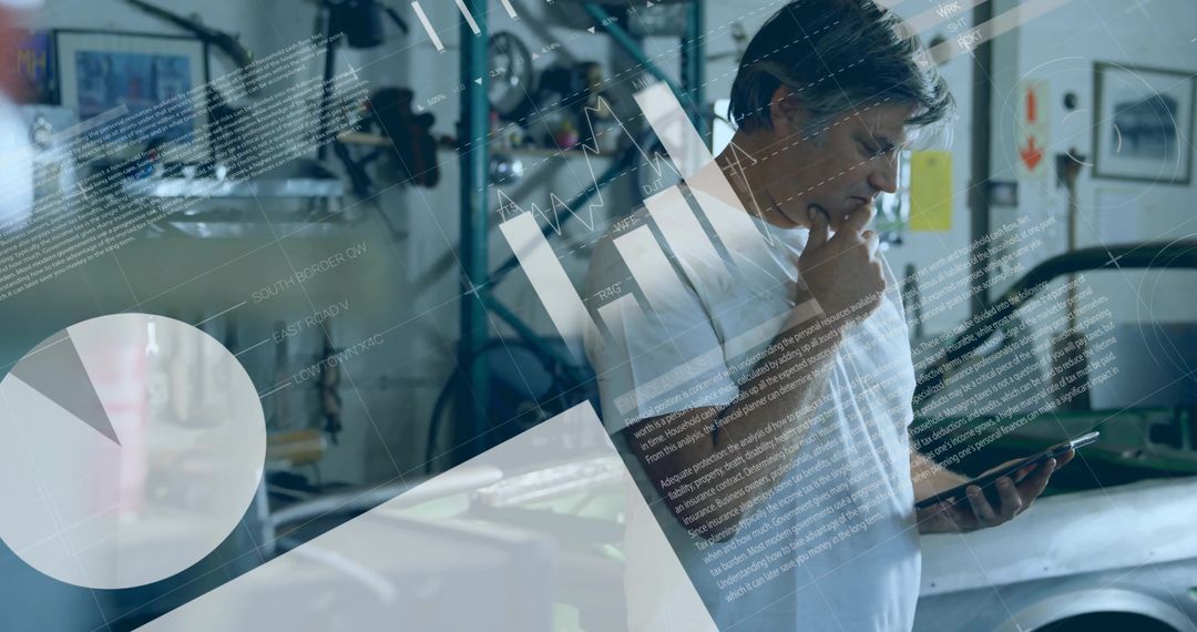 Mature Mechanic Analyzing Data on Tablet in Workshop Environment