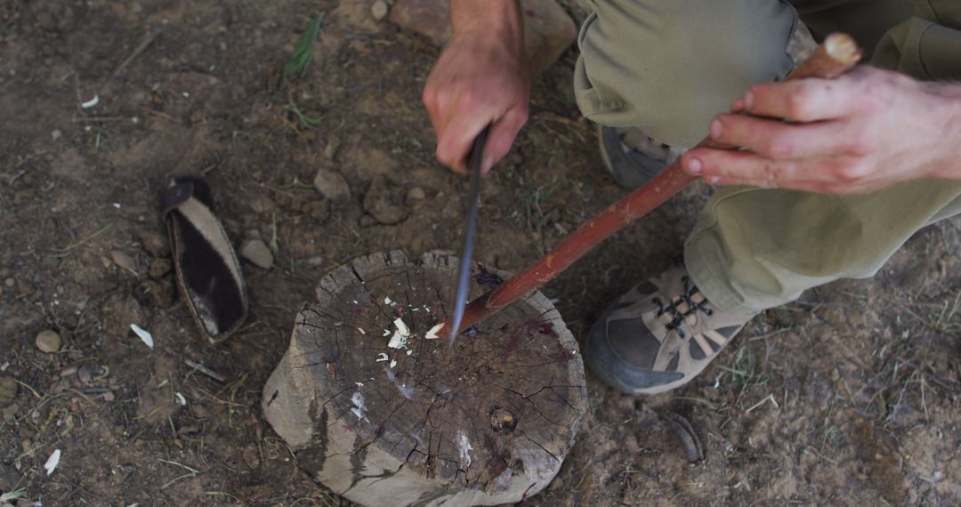 Person whittling wooden stick with knife on stump outdoors - Free Images, Stock Photos and Pictures on Pikwizard.com