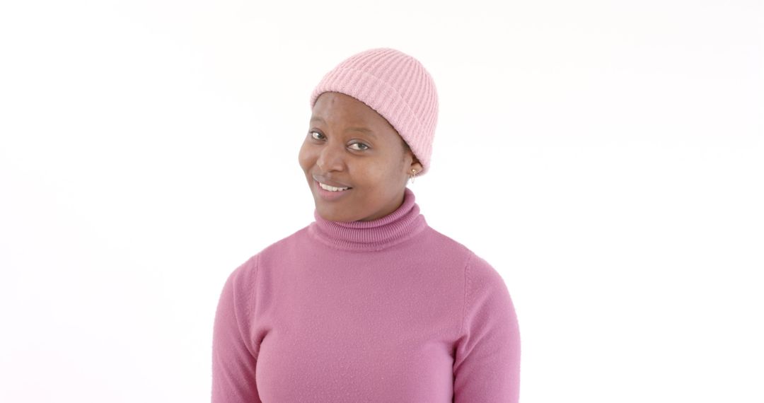 Smiling Woman in Pink Beanie and Sweater Exuding Confidence