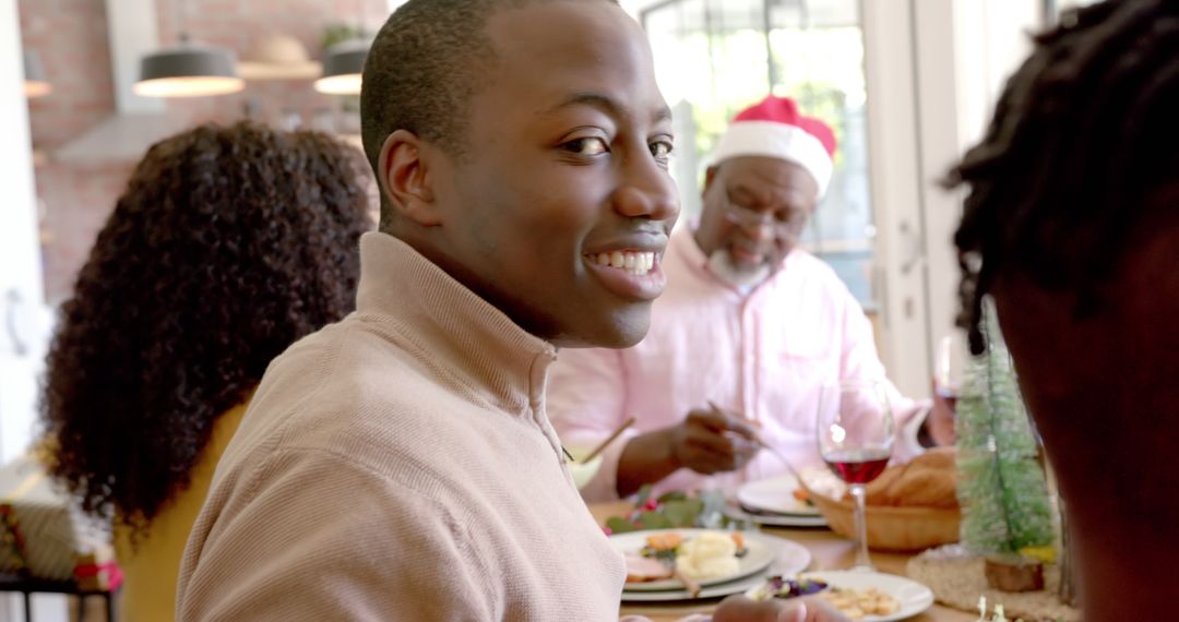 Smiling Young Man Enjoying Christmas Dinner with Family - Free Images, Stock Photos and Pictures on Pikwizard.com