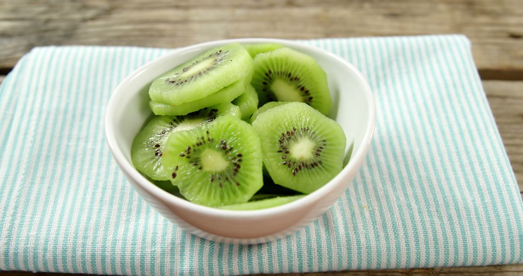 Fresh Sliced Kiwi Fruit in White Bowl on Striped Cloth - Free Images, Stock Photos and Pictures on Pikwizard.com