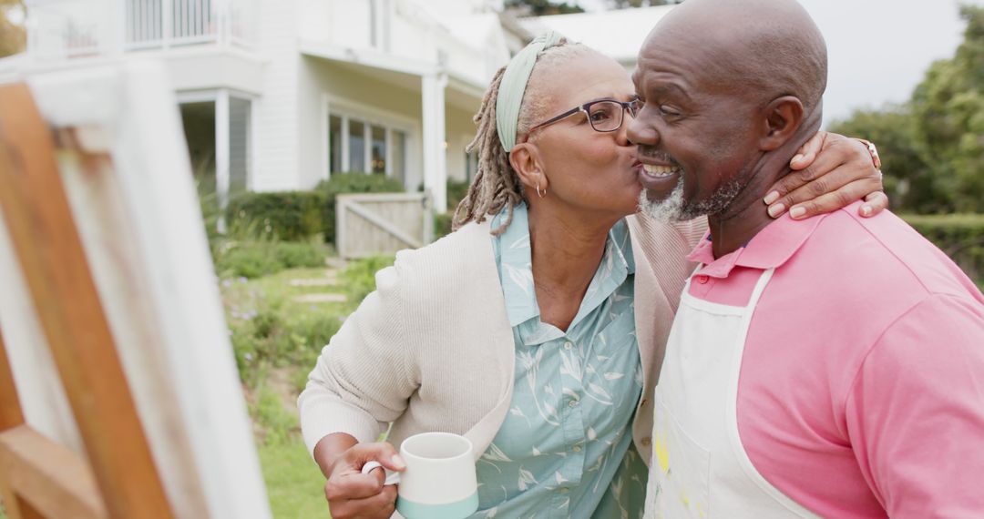 Elderly Couple Sharing a Warm Kiss Outdoors Amidst Painting Project - Free Images, Stock Photos and Pictures on Pikwizard.com