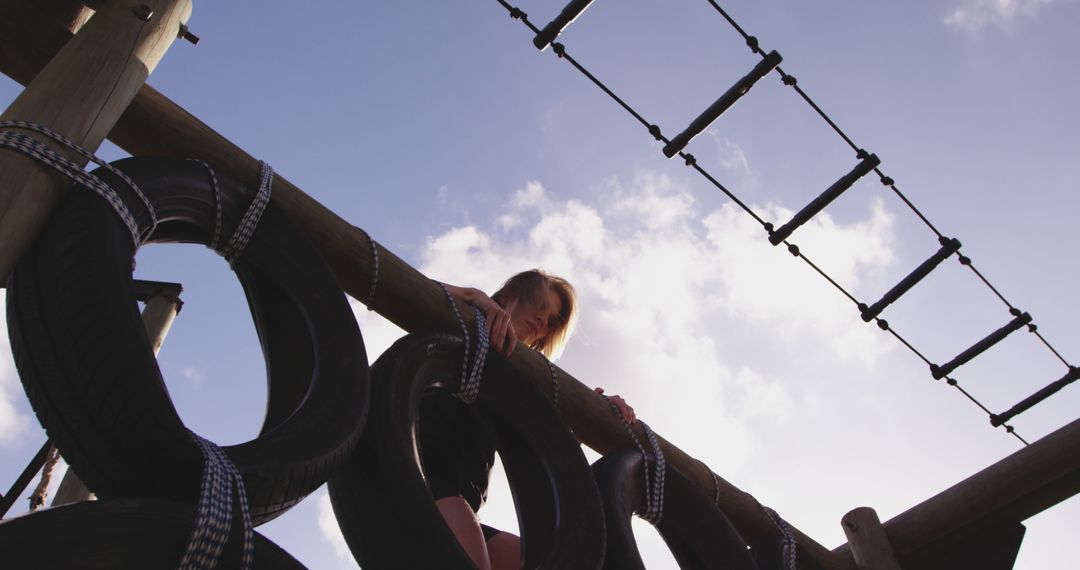 Caucasian Girl Climbing Adventure Playground with Tires