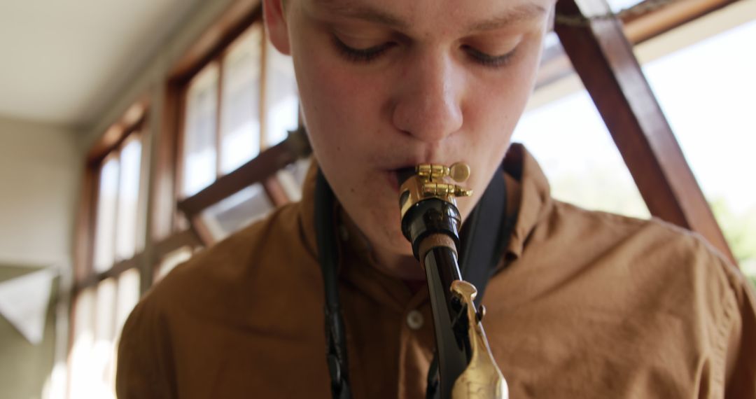 Young musician playing alto saxophone indoors - Free Images, Stock Photos and Pictures on Pikwizard.com