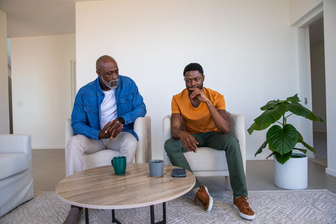 Two Men Enjoying Conversation with Coffee in Cozy Living Room