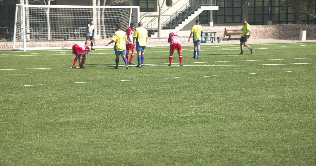Referee and Soccer Players in Action During Daytime Match