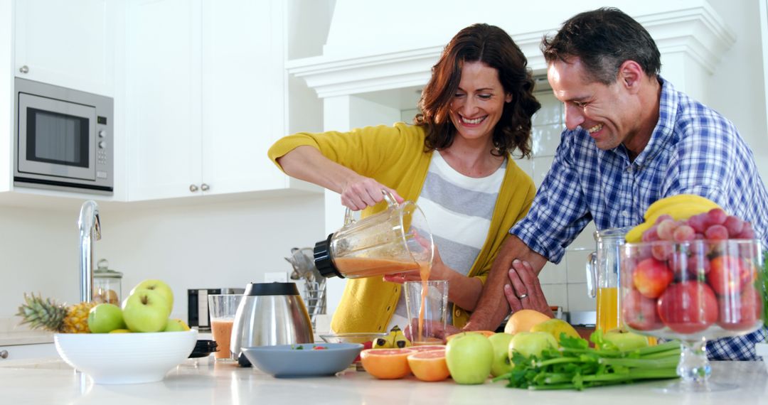 Happy Couple Preparing Smoothie Together in Modern Kitchen - Free Images, Stock Photos and Pictures on Pikwizard.com