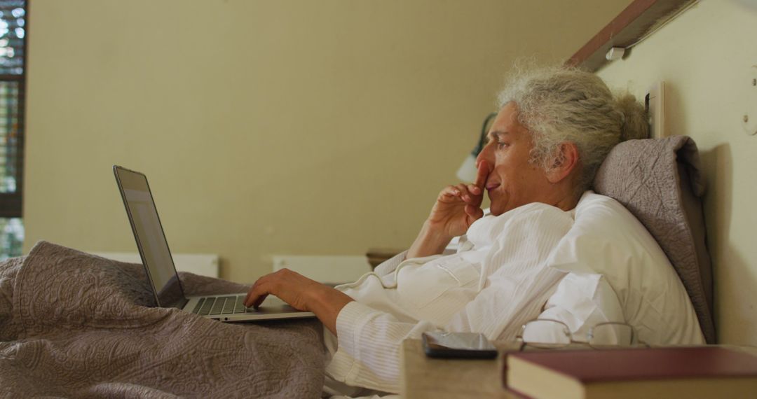 Elderly Woman Relaxing in Bed While Using Laptop - Free Images, Stock Photos and Pictures on Pikwizard.com