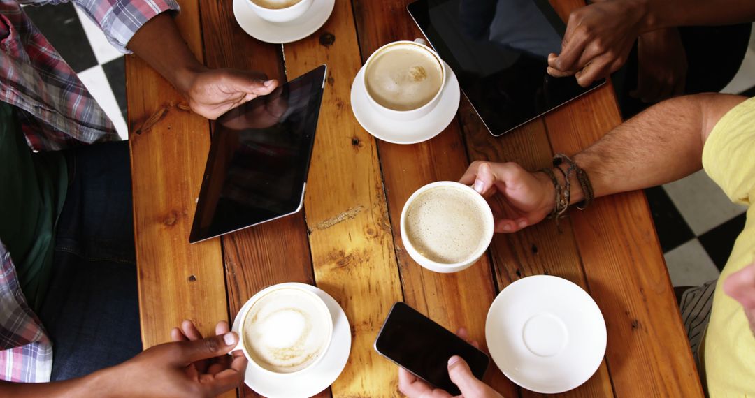 Group of friends using mobile phone and digital tablet while having cup of coffee in cafe 4k - Free Images, Stock Photos and Pictures on Pikwizard.com