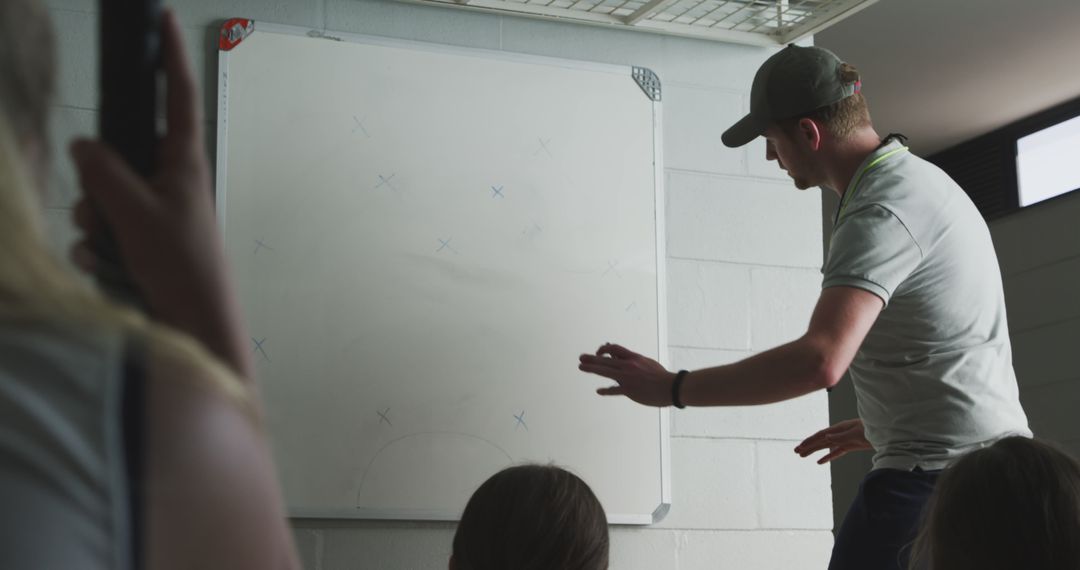 Coach Explaining Strategy on Whiteboard to Team - Free Images, Stock Photos and Pictures on Pikwizard.com