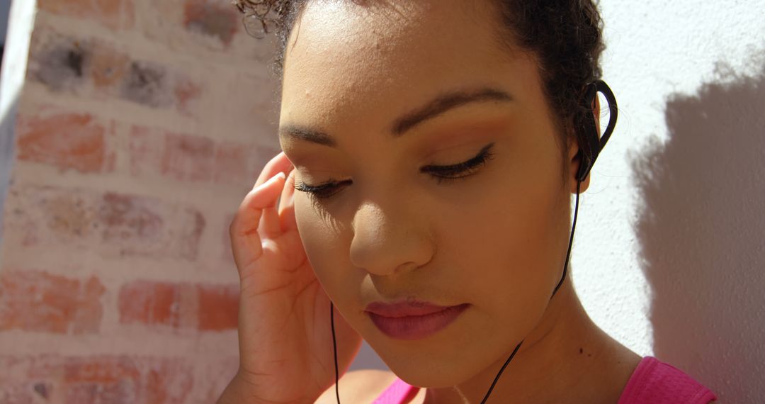 Woman Listening to Music with Earphones on Sunny Day - Free Images, Stock Photos and Pictures on Pikwizard.com