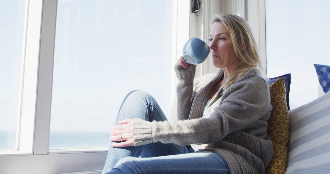 Woman Relaxing by Window with Coffee Cup - Free Images, Stock Photos and Pictures on Pikwizard.com