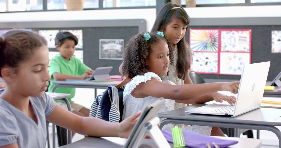 Multicultural Students Collaborating on Laptop in Classroom