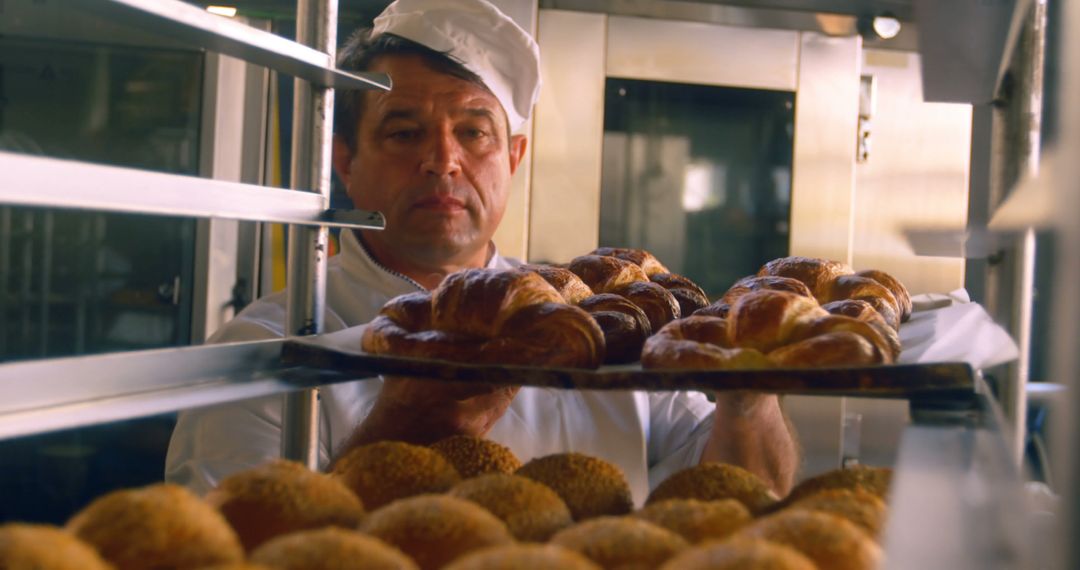 Baker arranging fresh croissants on tray - Free Images, Stock Photos and Pictures on Pikwizard.com