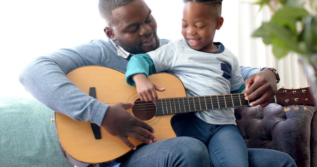 Father Teaching Son How to Play Guitar at Home - Free Images, Stock Photos and Pictures on Pikwizard.com