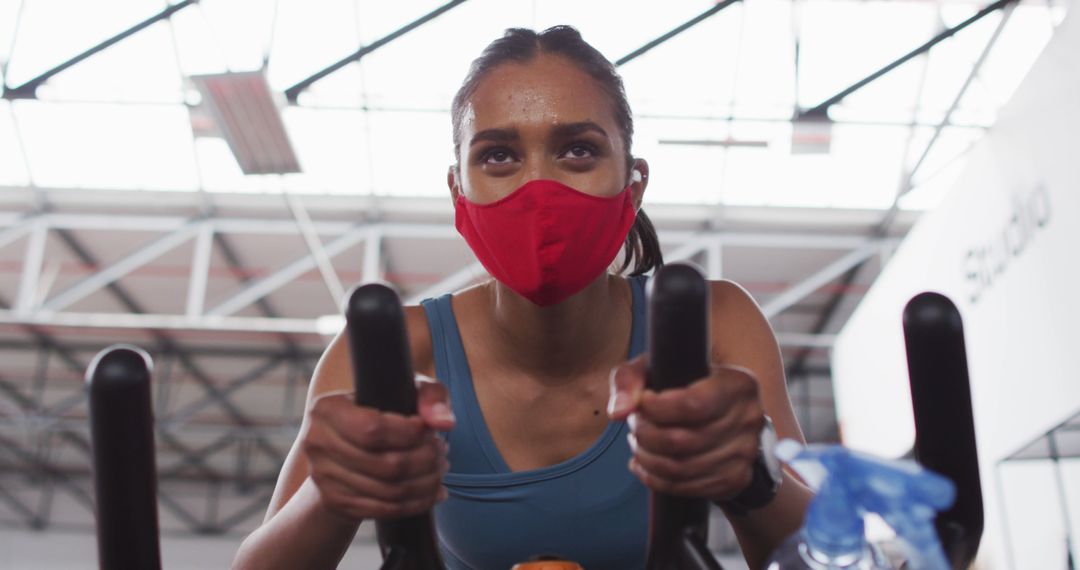 Young Woman Wearing Mask Exercising on Stationary Bike - Free Images, Stock Photos and Pictures on Pikwizard.com