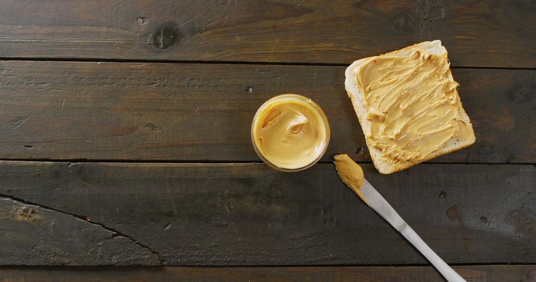 Toasted Bread with Creamy Peanut Butter Spread on Wooden Surface