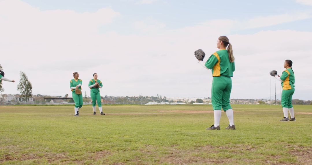 Diverse Female Softball Team Practicing on Field in Uniforms