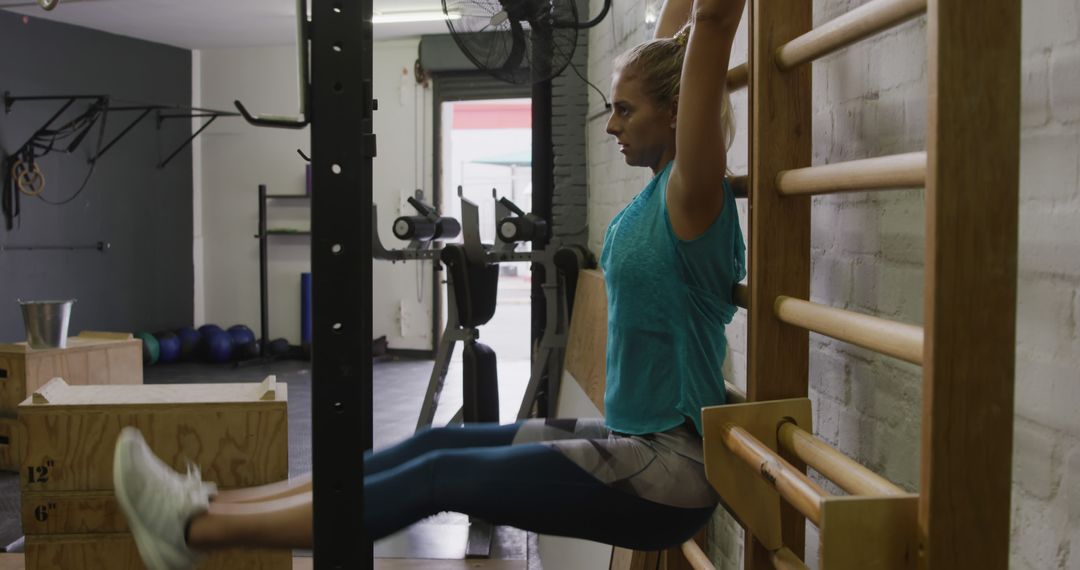 Woman Performing L-Sit Exercise on Stall Bars in Gym Setting - Free Images, Stock Photos and Pictures on Pikwizard.com