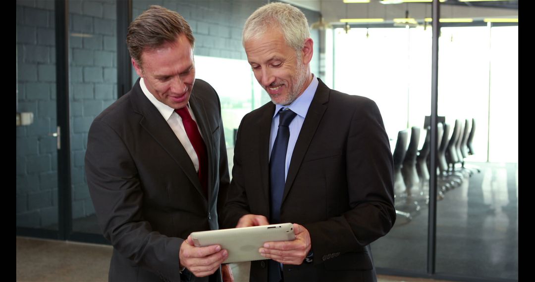 Business Partners Analyzing Digital Data on Tablet in Conference Room