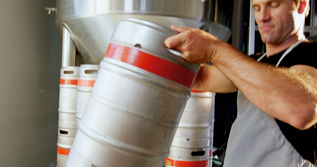 Brewery Worker Handling Beer Keg in Brewery - Free Images, Stock Photos and Pictures on Pikwizard.com