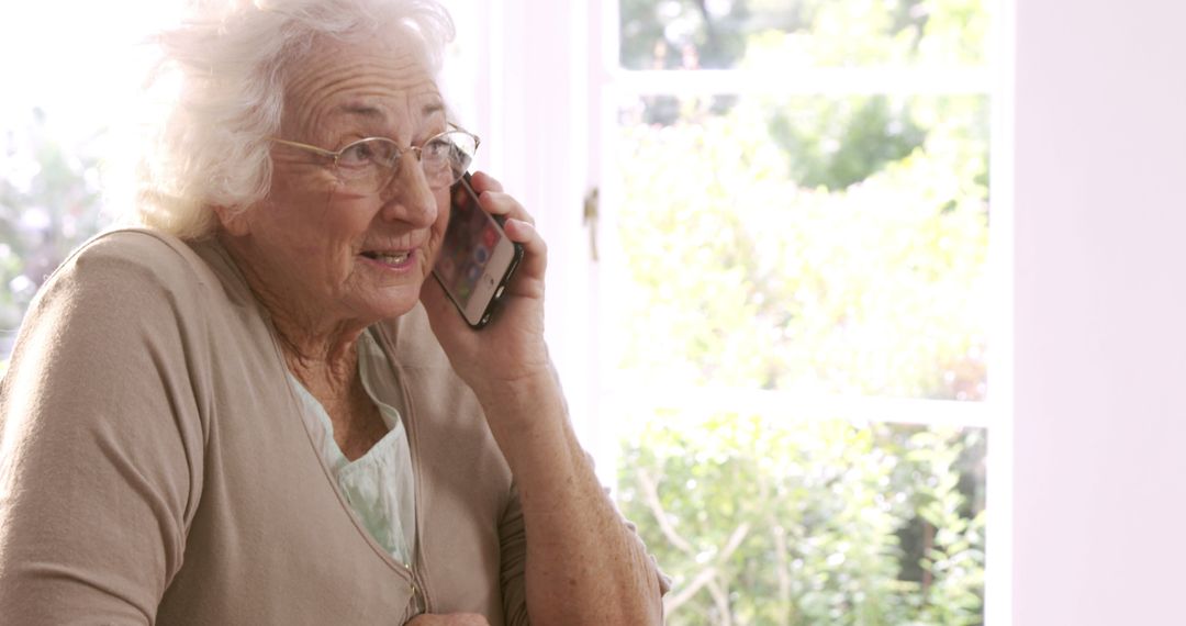 Senior Woman Talking on Smartphone in Bright Room - Free Images, Stock Photos and Pictures on Pikwizard.com