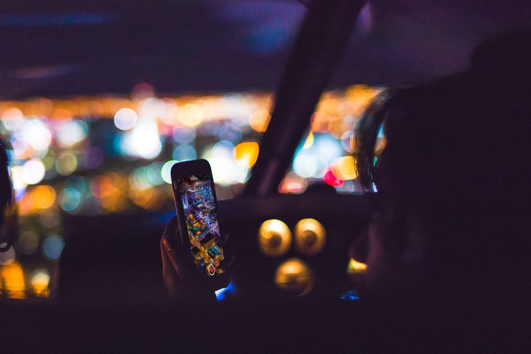 Person Using Smartphone at Night with City Lights in Background - Free Images, Stock Photos and Pictures on Pikwizard.com