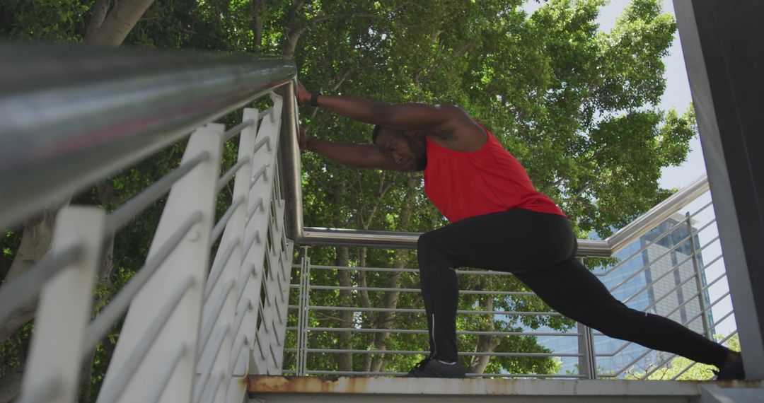 Man in Red Tank Top Stretching Outdoors on Staircase - Free Images, Stock Photos and Pictures on Pikwizard.com