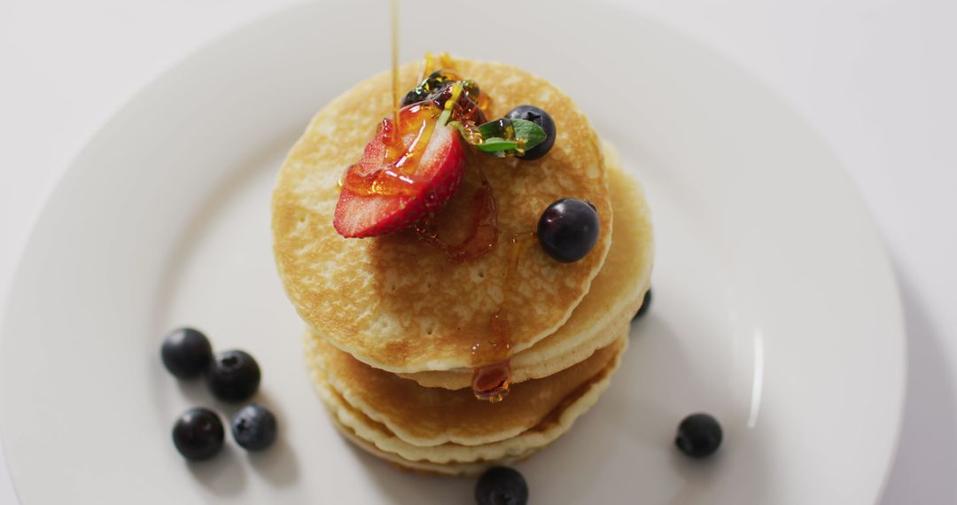 Stack of Fluffy Pancakes Drizzled with Honey and Berries