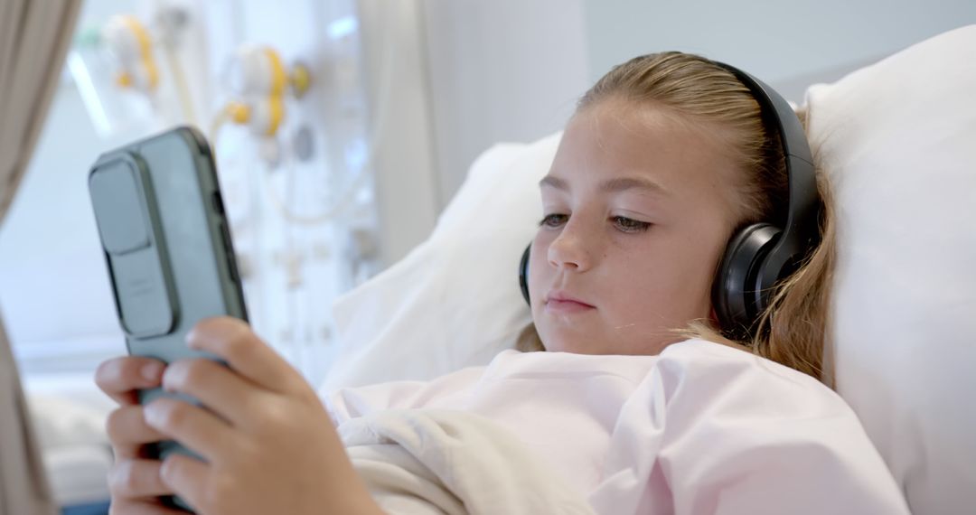 Young Girl in Hospital Bed Using Smartphone and Headphones - Free Images, Stock Photos and Pictures on Pikwizard.com