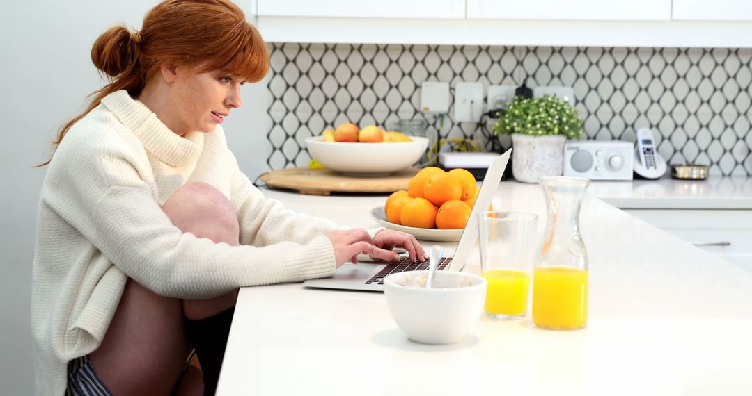 Woman Working on Laptop in Modern Kitchen with Fresh Oranges and Juice - Free Images, Stock Photos and Pictures on Pikwizard.com