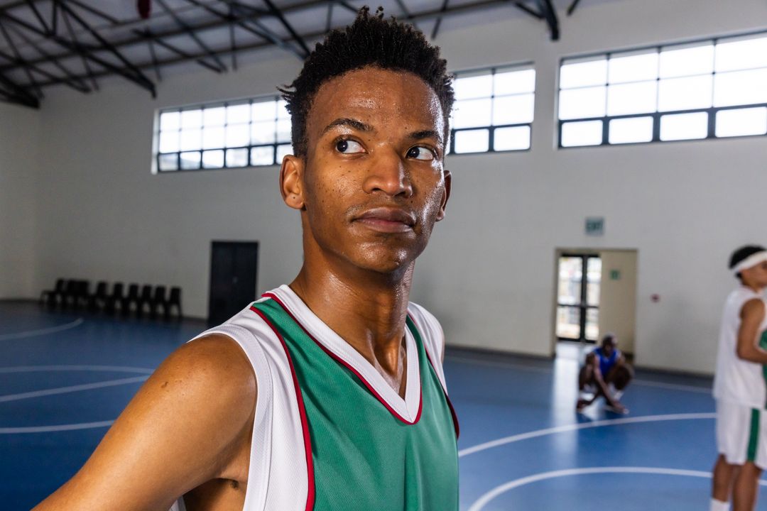 Focused Basketball Player Standing Confidently in Indoor Court