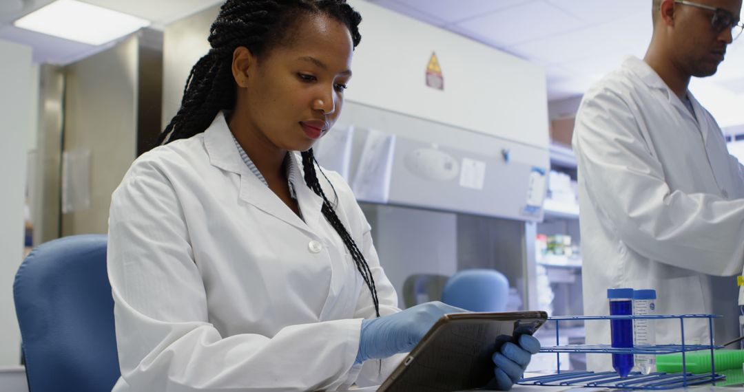 Scientist Analyzing Data on Tablet in Modern Laboratory - Free Images, Stock Photos and Pictures on Pikwizard.com