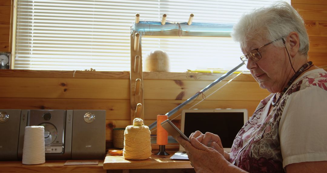 Senior Woman Using Tablet in Bright Craft Workshop