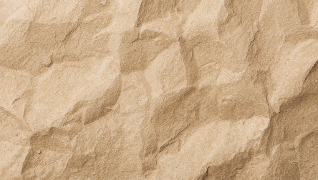 Crumpled Kraft Paper Texture Showing Creases Fibers Speckles and Warm Beige Wrinkled Surface