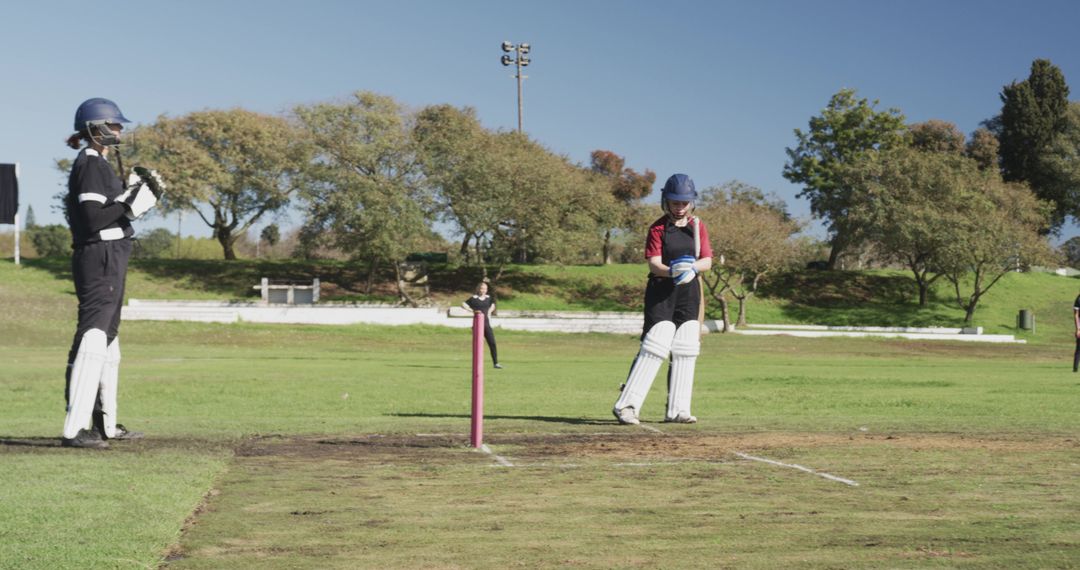 Female Cricketers Preparing on Sunlit Field