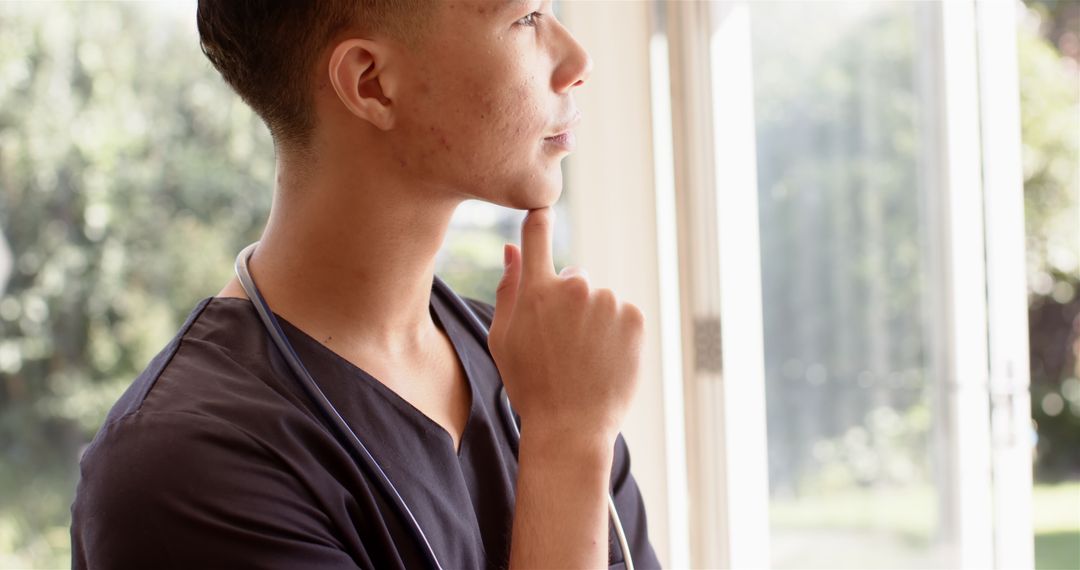 Male Physiotherapist Meditating by Window for Relaxation and Wellness