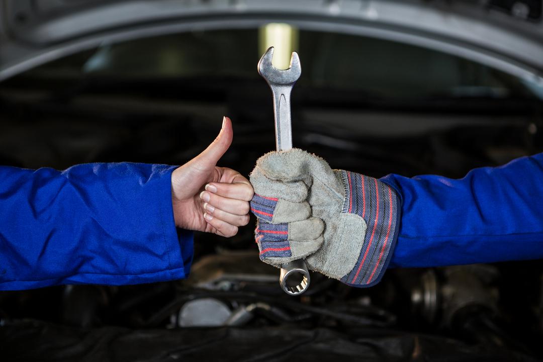 Mechanics holding spanner and showing thumbs up - Free Images, Stock Photos and Pictures on Pikwizard.com