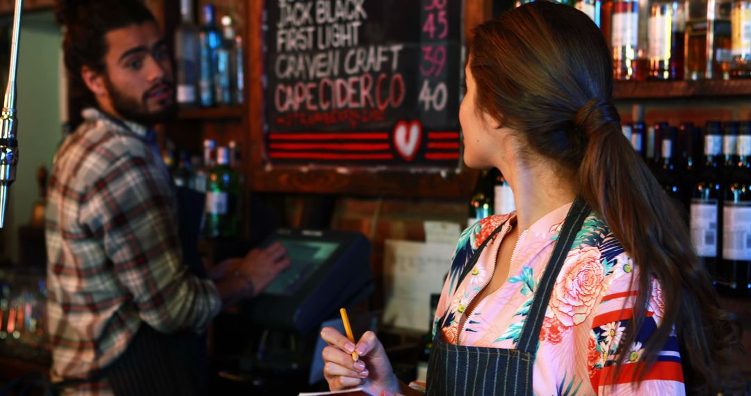 Bartender Taking Order from Customer in Lively Pub Environment