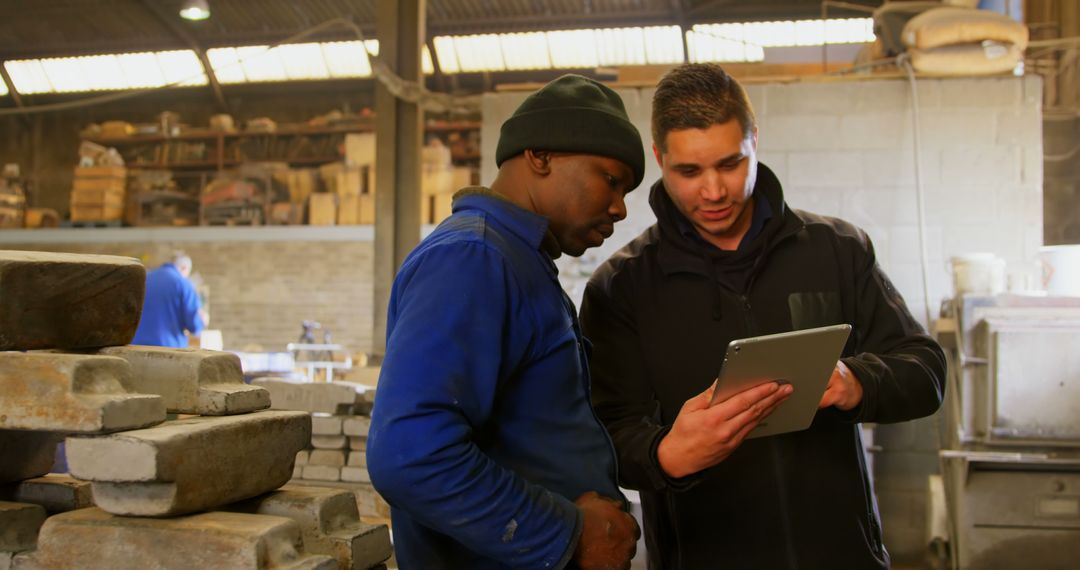 Workers Reviewing Plans on Digital Tablet in Industrial Workshop - Free Images, Stock Photos and Pictures on Pikwizard.com